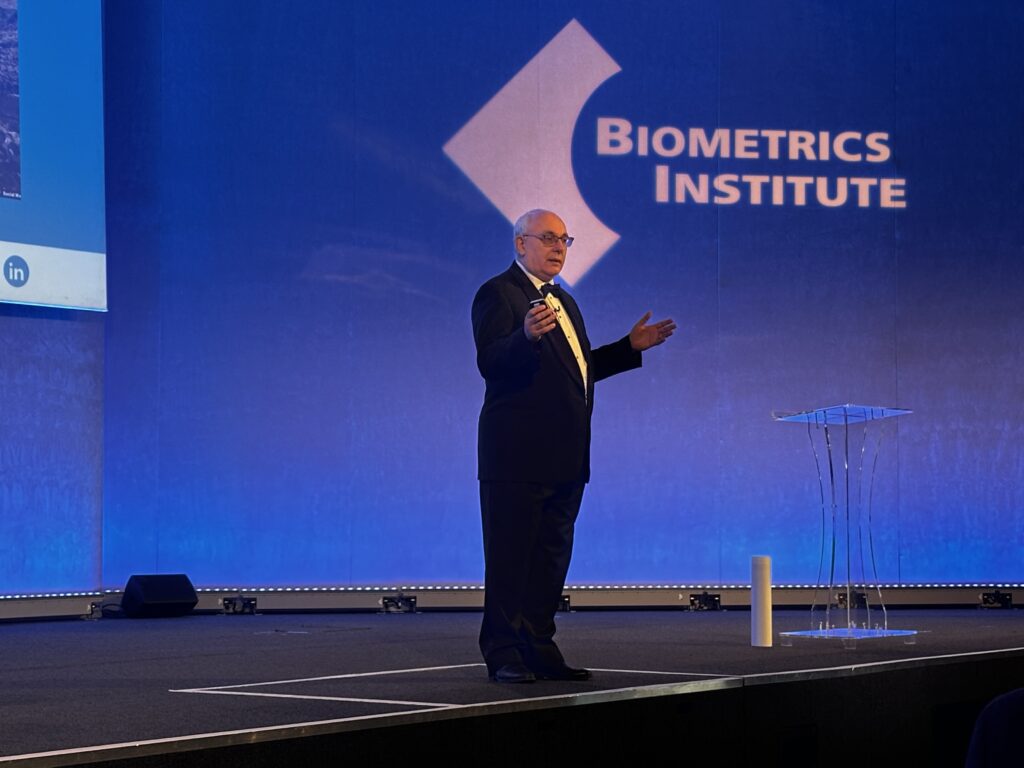 Biometrics Institute Congress 2023 David on stage in his tuxedo talking about how difficult the job would be for James Bond in this day and age. 