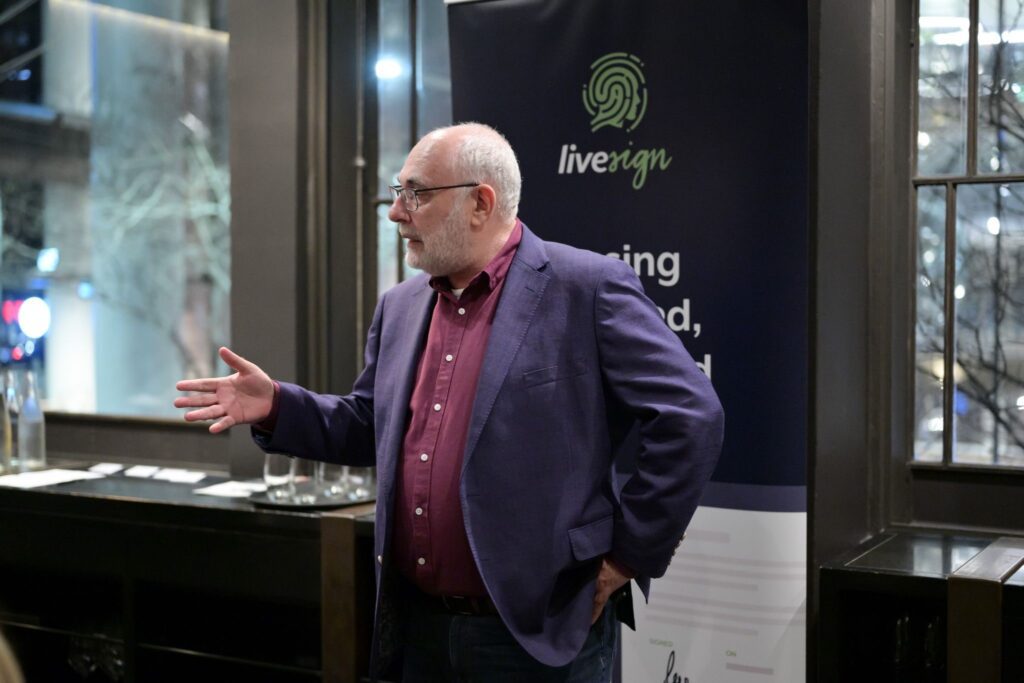 Digital Identity Tour Down Under: LiveSign Dinner - David Birch stood in front of LiveSign banner giving his talk