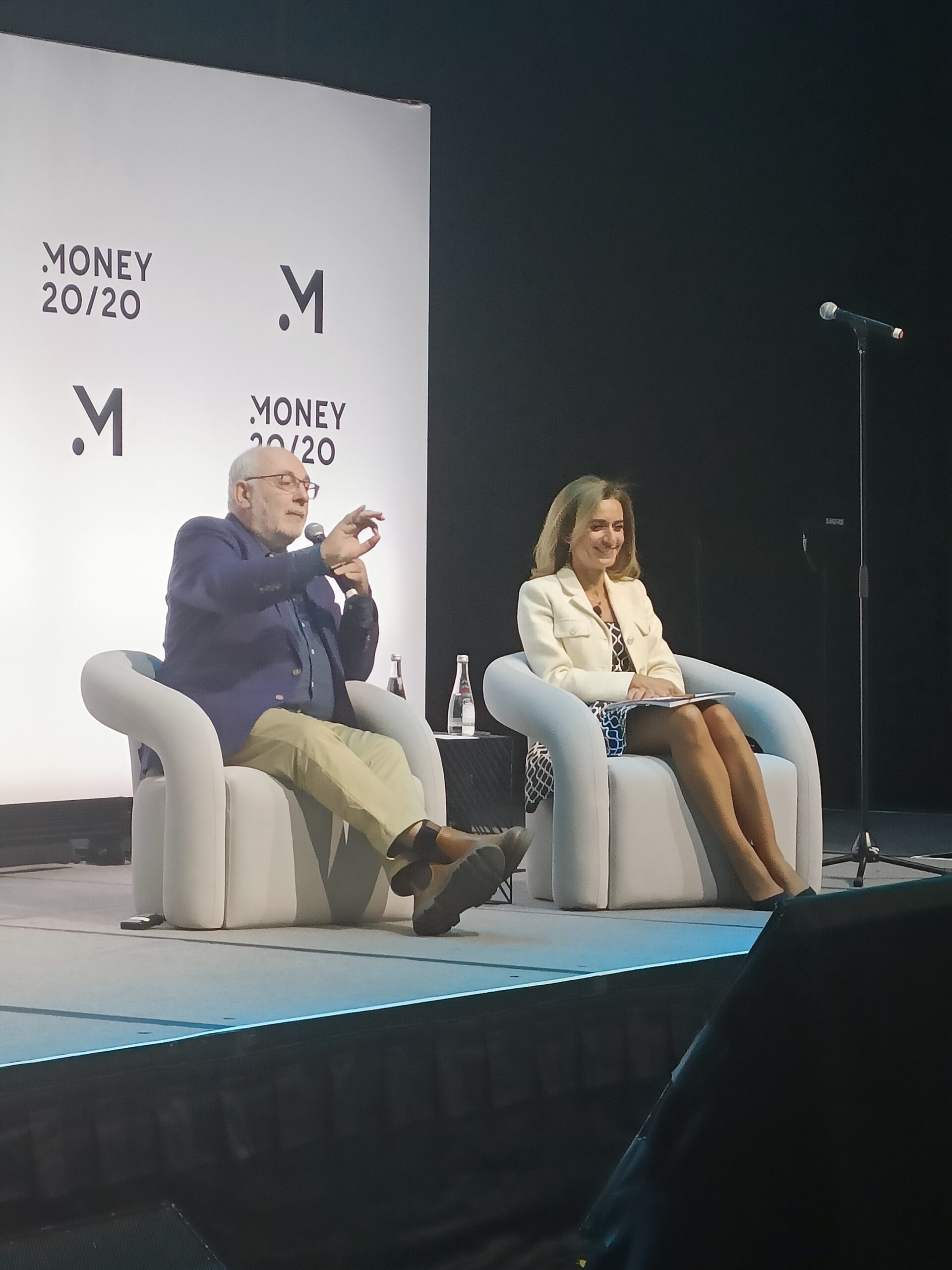 David Birch & Sophia Bantinidis sat in chairs on stage for their fireside chat: Have my AI call your AI and let's do lunch