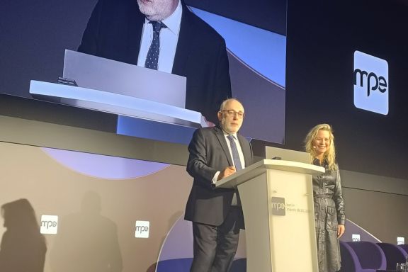 Opening MPE 2025: David Birch & Rith Wandhofer standing at the podium on stage opening the show