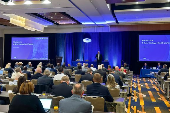David Birch on stage at the secure cash and transport association conference speaking about the history and future of stablecoins. 